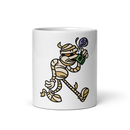 A white ceramic mug featuring a cartoon illustration of a mummy running while holding a green bag with a dollar sign, on a clean white background.